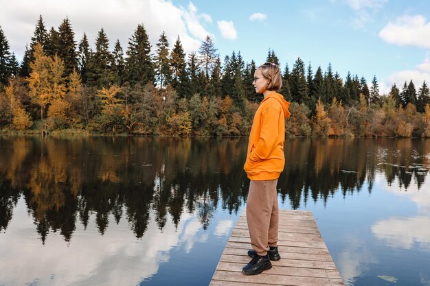 Mädchen ist im Herbstpark Herbstatmosphäre malerische Aussicht auf den Fluss