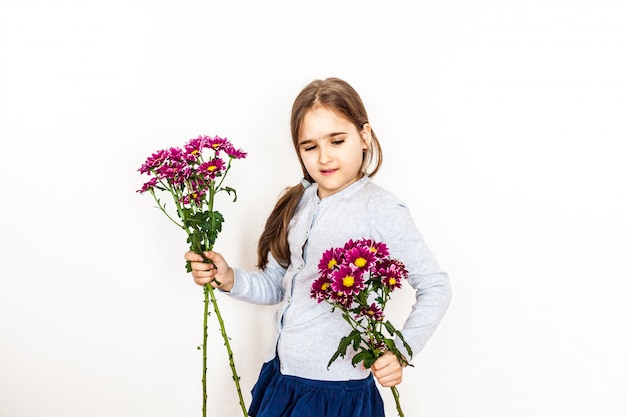 Mädchen, Kind, das einen Blumenstrauß hält, helle Farben auf dem Gesicht, Gefühle, Geschenk, Kinder, Feiertag