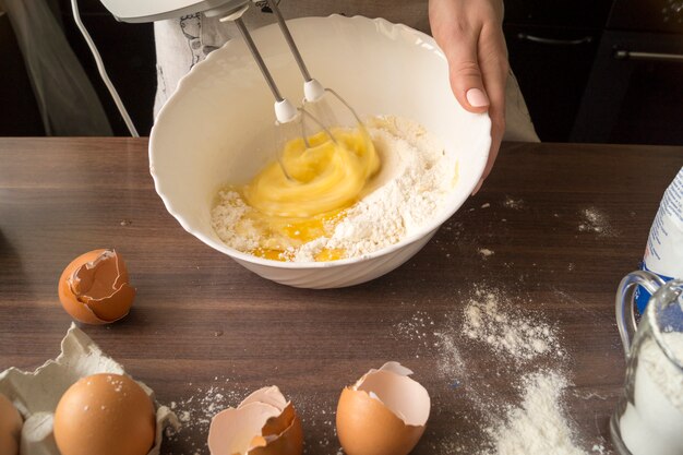 Mädchen knetet den Teig mit einem Mixer