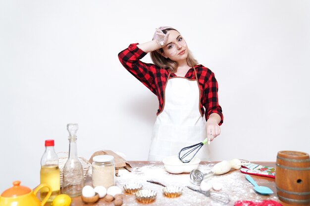 Mädchen kochen, Mädchen in Schürze, Mädchen lustig mit Mehl befleckt, die Köchin ist müde