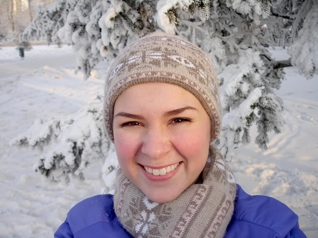 Mädchen lächelt im verschneiten Wald Selfie