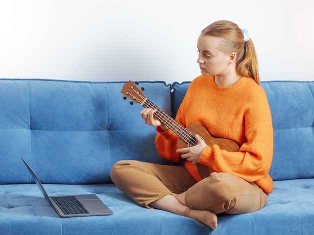 Mädchen lernt aus der Ferne Ukulele spielen