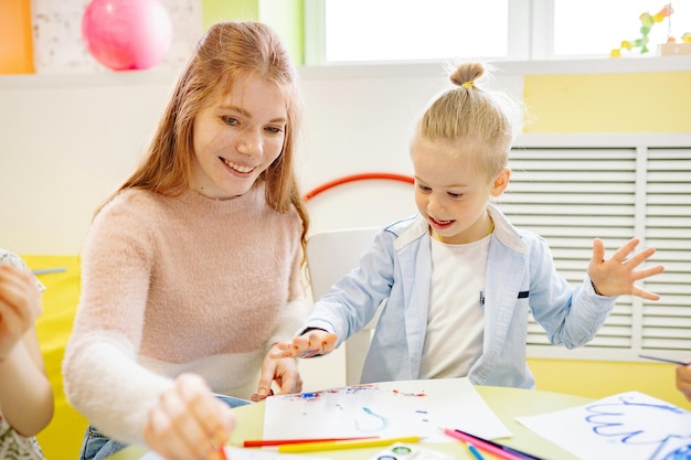 Mädchen lernt mit ihrem Lehrer malen