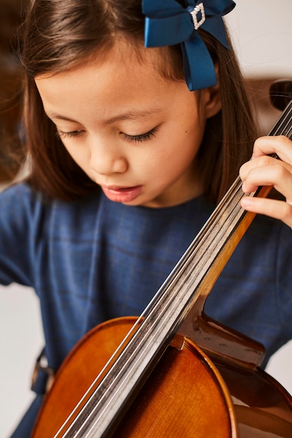 Mädchen lernt, wie man zu Hause Cello spielt