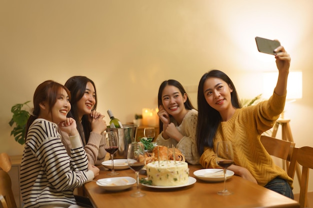 Foto mädchen machen ein selfie mit freunden auf einer asiatischen geburtstagsfeier