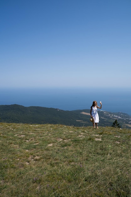 Mädchen macht ein Selfie vor dem Hintergrund einer wunderschönen Landschaft