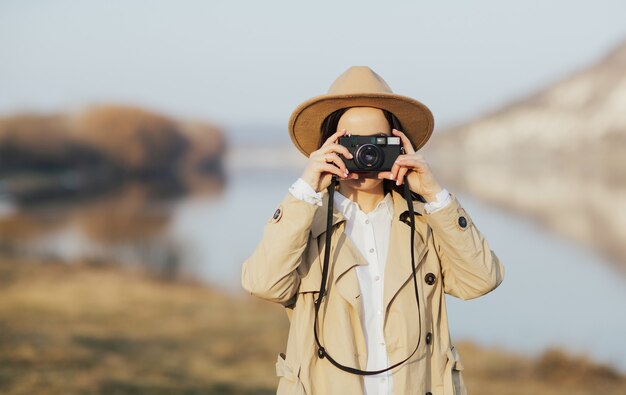 Mädchen macht Fotos mit einer Retro-Kamera im Berg