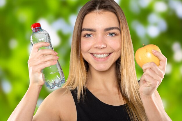 Mädchen mit Apfel und Flasche Wasser