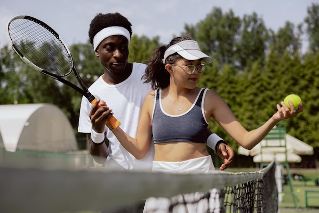 Mädchen mit asiatischem Aussehen kam zum ersten Trainer der Tennisstunde