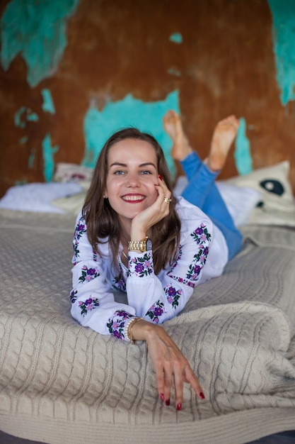 Mädchen mit braunen Haaren liegt auf dem Bett