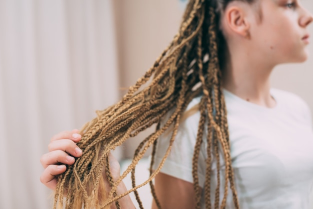 Mädchen mit braunen Haaren und Zöpfen mit künstlichem Haar geflochten