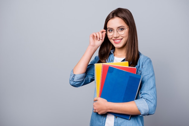 Mädchen mit Brille hält eine Reihe von Notizbüchern