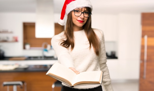 Mädchen mit dem Feiern der Weihnachtsfeiertage, die ein Buch halten und es jemandem zu Hause geben