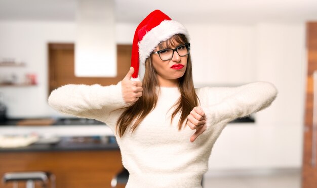 Mädchen mit dem Feiern der Weihnachtsfeiertage, die gut-schlechtes Zeichen machen.