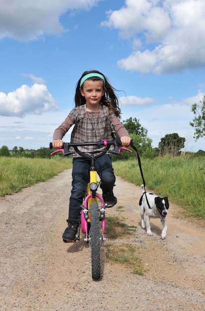 Mädchen mit dem Hund auf dem Fahrrad