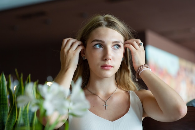 Foto mädchen mit den blauen augen, die auf städtischem café sitzen. frau mit brauner gewellter frisur. lifestyle-konzept.