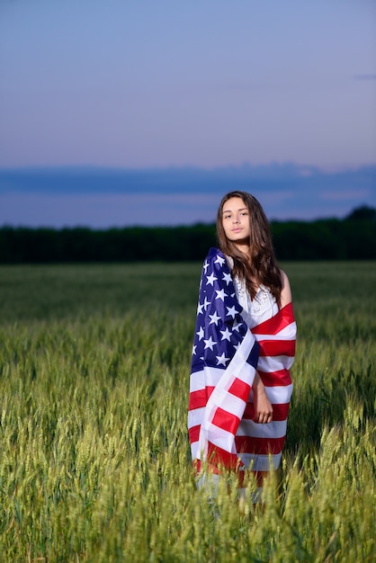 Foto mädchen mit der amerikanischen flagge auf ihren schultern