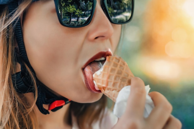 Foto mädchen mit dunkler brille leckt eiscreme