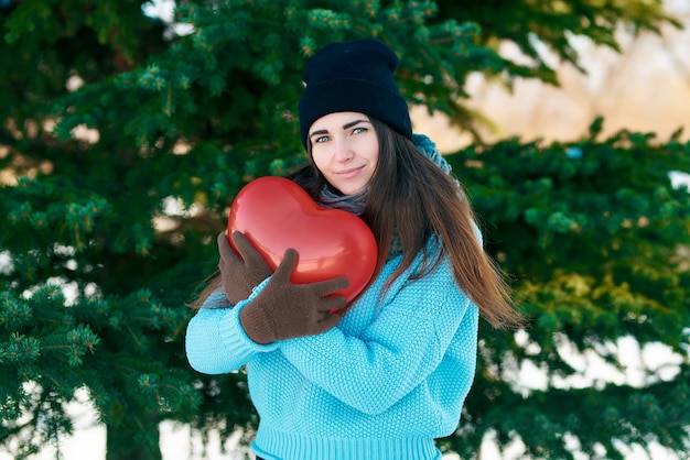 Mädchen mit einem Ballon in Form eines Herzens in den Händen. Valentinstag