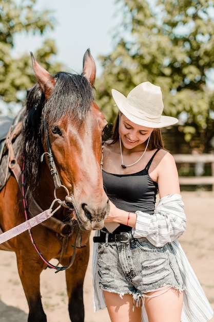 Mädchen mit einem braunen Pferd auf dem Bauernhof