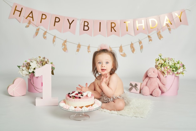 Mädchen mit einem Geburtstagskuchen, 1-jährige Babyfotosession