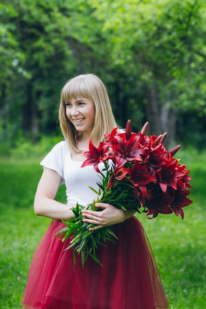 Mädchen mit einem großen Strauß lila Lilien