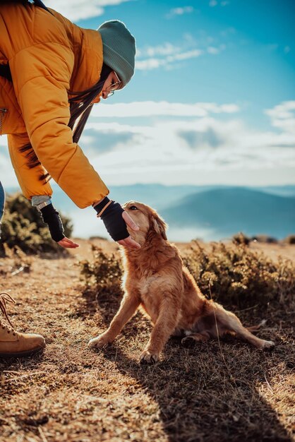 Mädchen mit einem Hund spielen in den Bergen Herbststimmung Unterwegs mit einem Haustier Frau und ihr Hund posieren im Freien