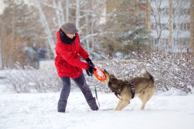 Mädchen mit einem jungen Hund auf einem Winterspaziergang Haustiertraining Selektive Fokussierung