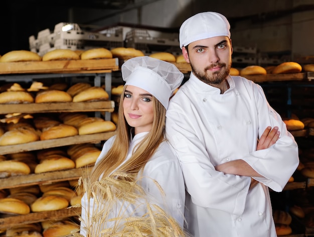 Mädchen mit einem Kerl im weißen Overall in der Bäckerei