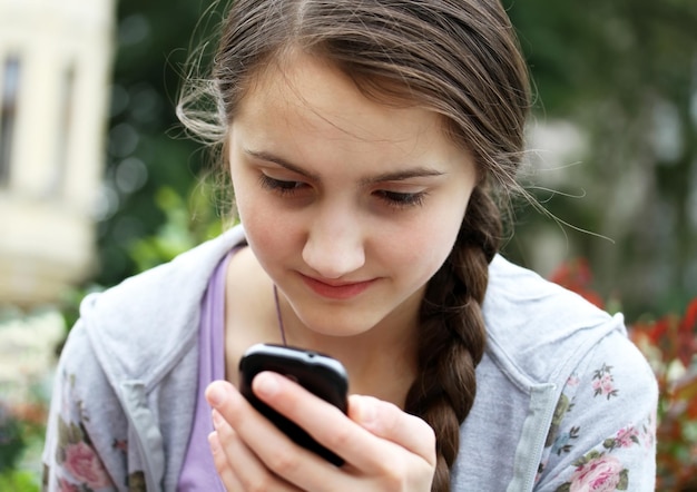 Mädchen mit einem Mobiltelefon liest die Nachricht