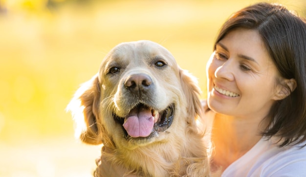 Mädchen mit einem schönen Golden Retriever-Hundporträt auf einem verschwommenen Hintergrund