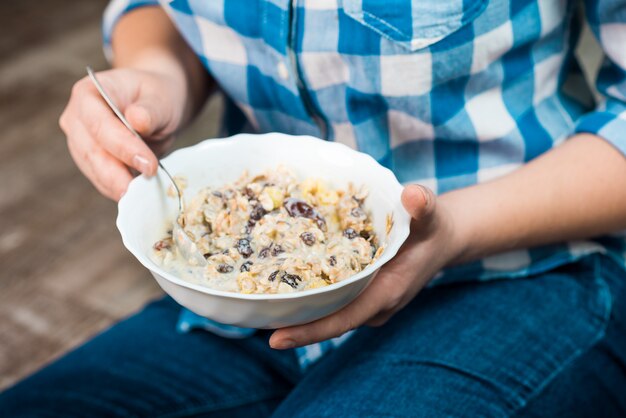 Mädchen mit einem Teller Vollkorngetreide mit Joghurt