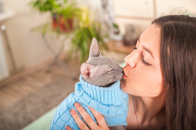 Mädchen mit einer Katze im Schlafzimmer auf dem Bett. Haustiere und Menschen.