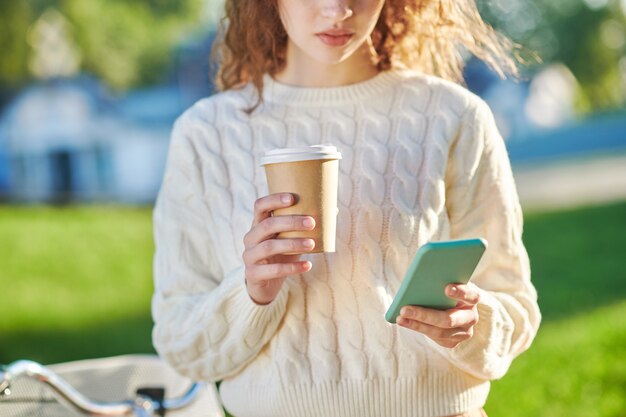 Mädchen mit einer Tasse Kaffee liest eine Nachricht im Messenger