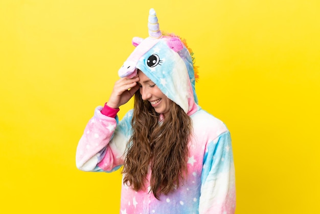 Mädchen mit Einhorn-Pyjama vor isoliertem Hintergrund lachend