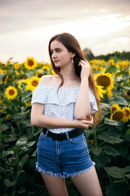 Mädchen mit gelbem Blumenstrauß des blühenden Sonnenblumenfeldes