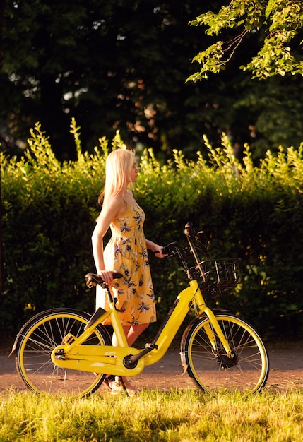 Mädchen mit gelbem Elektrofahrrad im Park