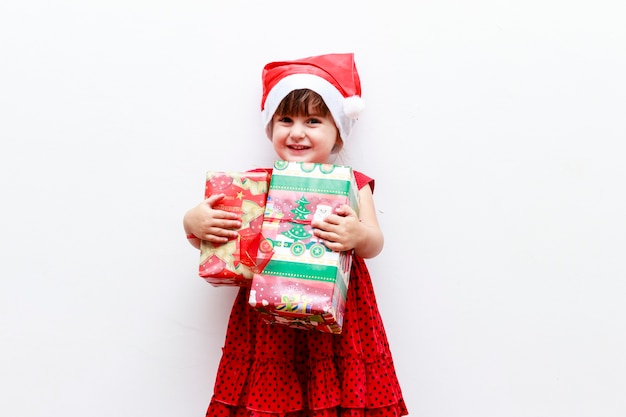 Mädchen mit Geschenken und Weihnachtsmütze, weißer Hintergrund