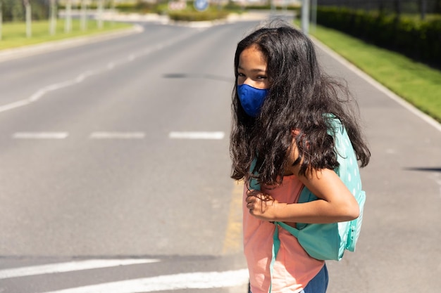 Mädchen mit Gesichtsmaske steht auf der Straße