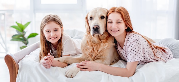 Mädchen mit Golden Retriever Hund im Bett