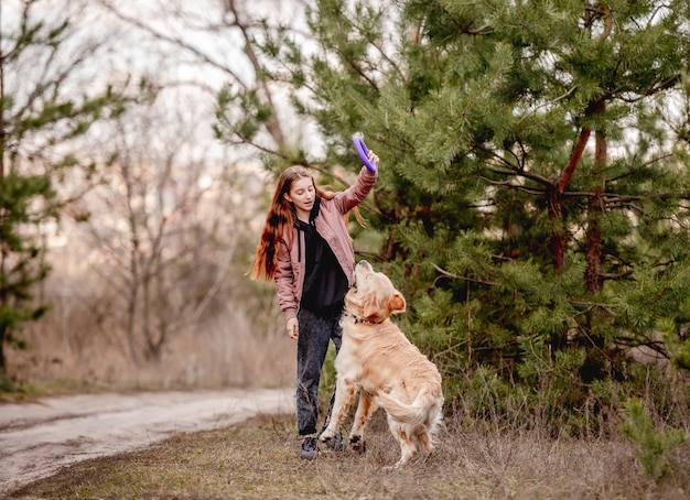 Mädchen mit Golden Retriever Hund im Wald