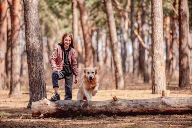 Mädchen mit Golden Retriever Hund im Wald