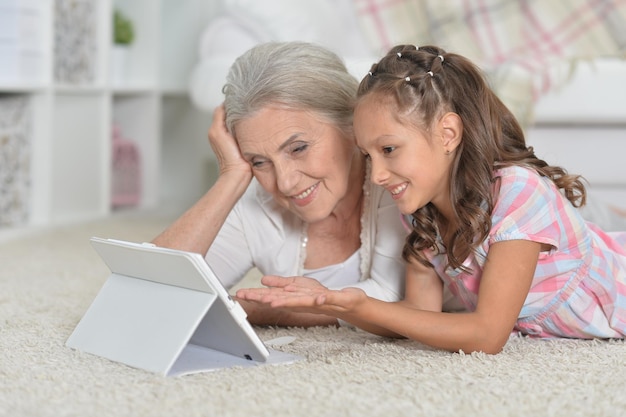 Mädchen mit Großmutter, die ein Tablet benutzt