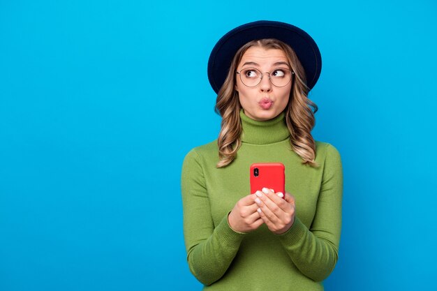 Mädchen mit Hut und Brille hält Telefon