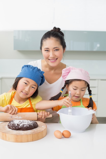 Mädchen mit ihrer Mutter, die Plätzchen in der Küche vorbereitet