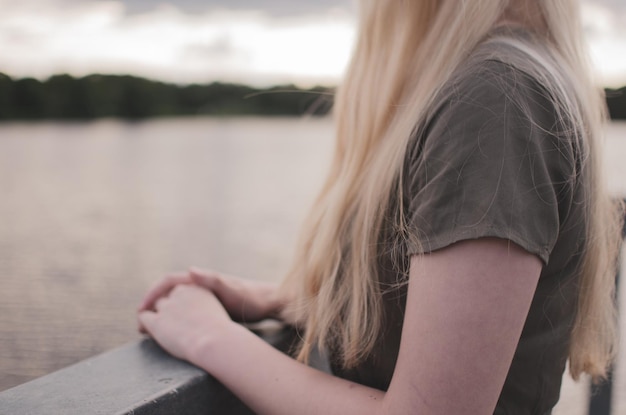 Foto mädchen mit langen blonden haaren besorgt händchen haltend