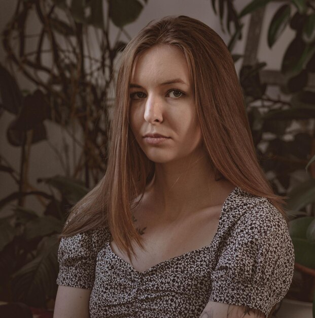 Mädchen mit langen Haaren auf dem Hintergrund von Laub