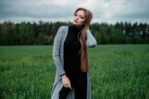 Mädchen mit langen Haaren, die im Wind auf dem Feld stehen Konzept der Freiheit und Leidenschaft