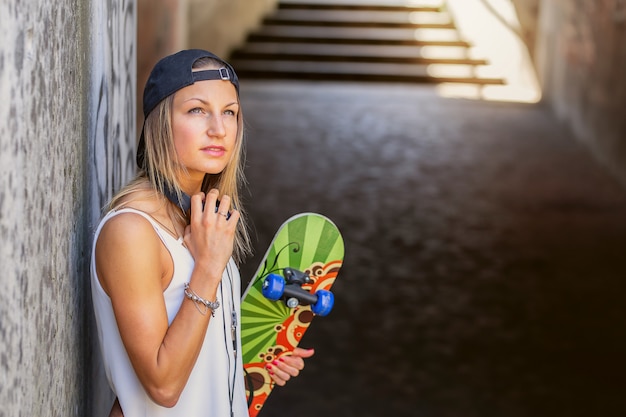 Mädchen mit langen Haaren halten ihr Skateboard