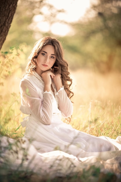 Mädchen mit langen Haaren in einem alten Kleid im Garten